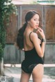 A woman in a black bodysuit posing for a picture.
