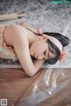 A woman laying on the floor with a plastic bag over her head.