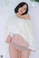 A woman in a white fuzzy sweater is posing for a picture.