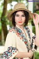 A woman wearing a straw hat is posing for a picture.