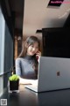 A woman sitting at a table with a laptop and talking on a cell phone.