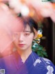 A woman in a blue kimono with a flower in her hair.